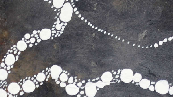 Détail de l'oeuvre, tentacule sous-marine blanche peinte sur une ardoise grise